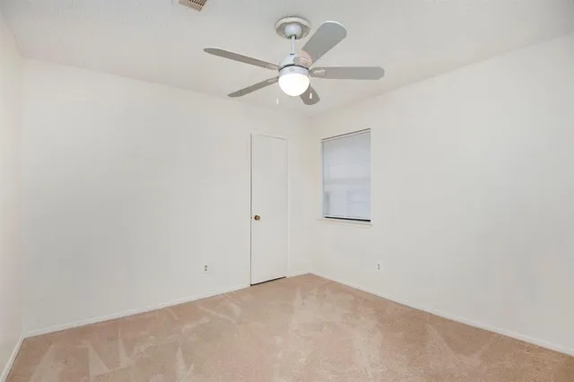an empty room with a fan and a fan