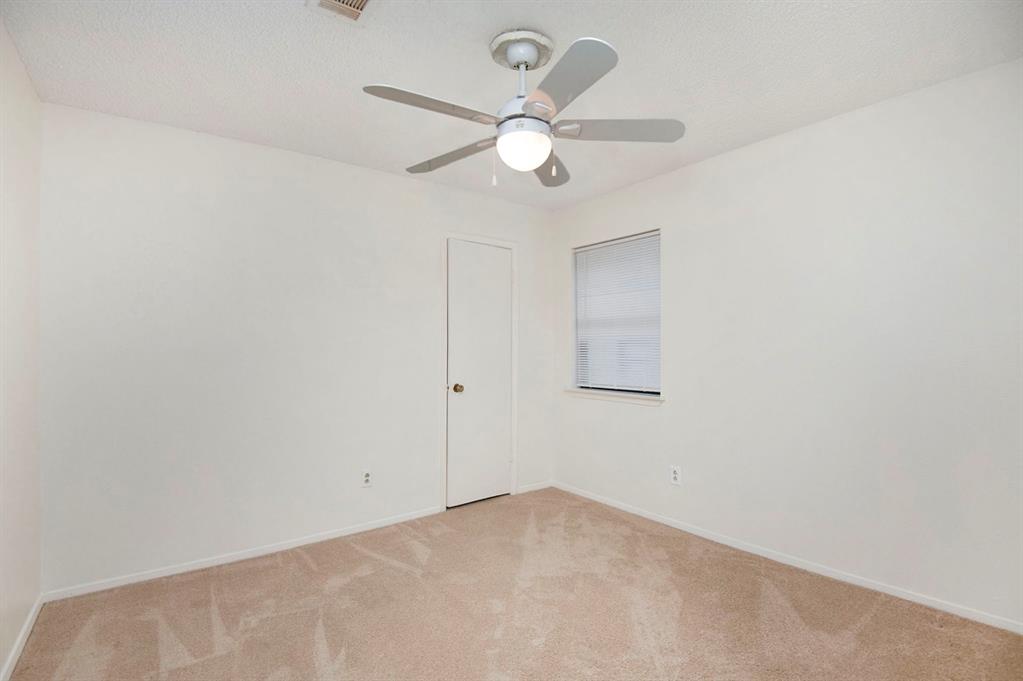 6817 West Cleburne Road Fort Worth, TX 76133 - Photo 19 of 24 an empty room with a fan and a fan