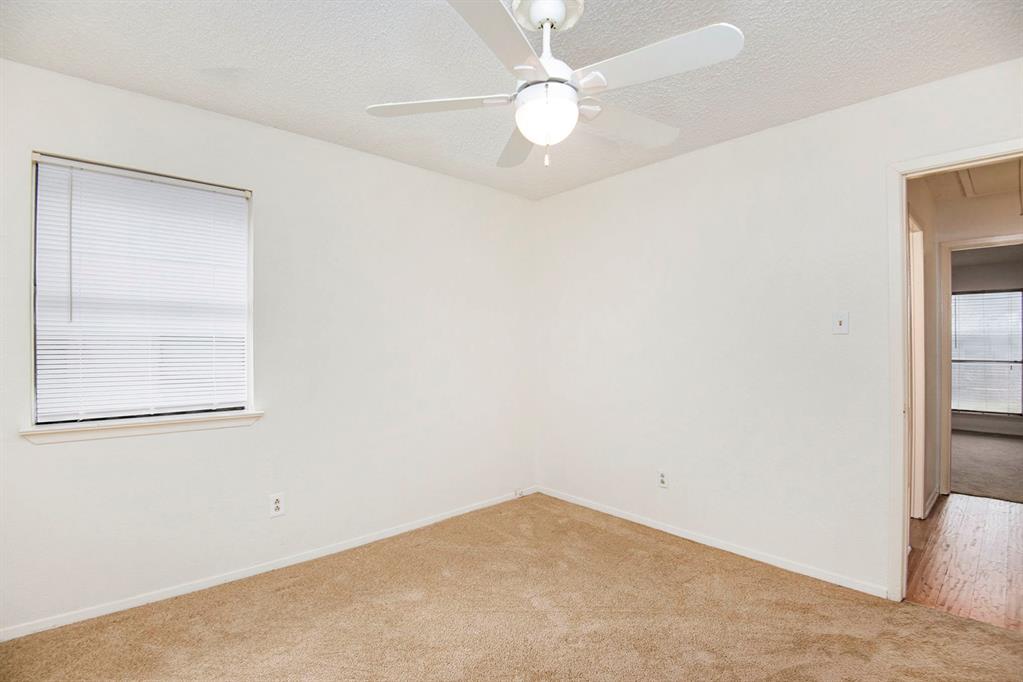 6817 West Cleburne Road Fort Worth, TX 76133 - Photo 20 of 24 an empty room with a window and a fan