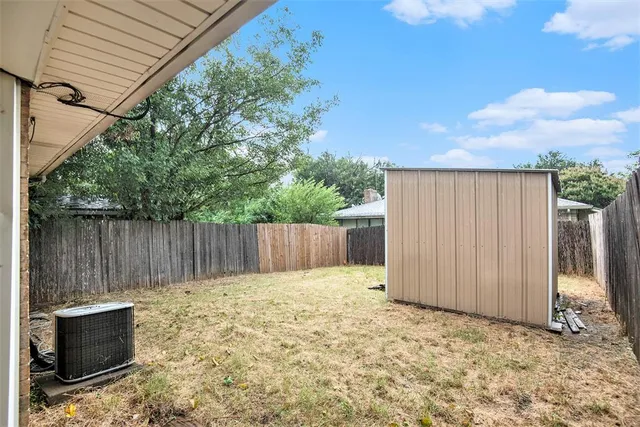 a view of a backyard with wooden fence