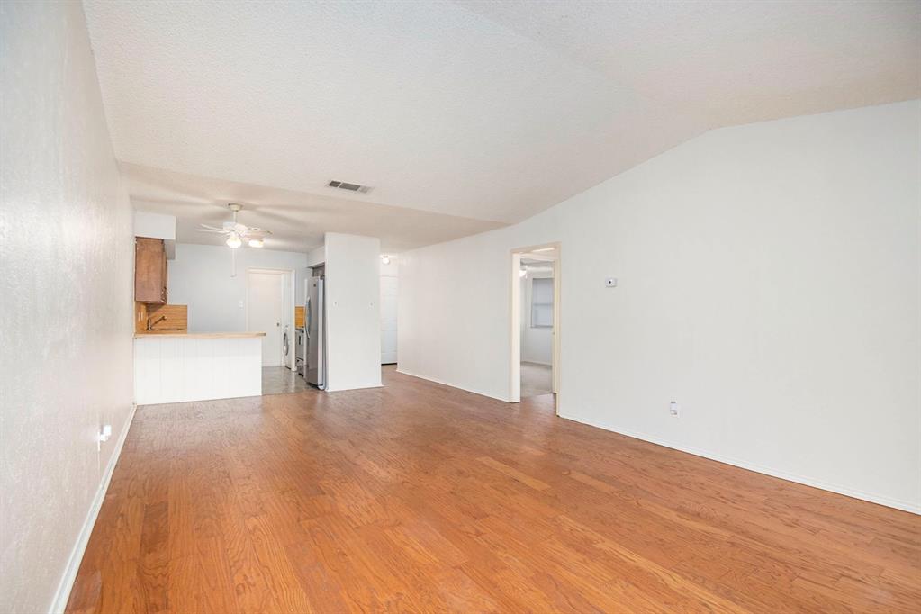 6817 West Cleburne Road Fort Worth, TX 76133 - Photo 8 of 24 a view of a big room with wooden floor and a large window