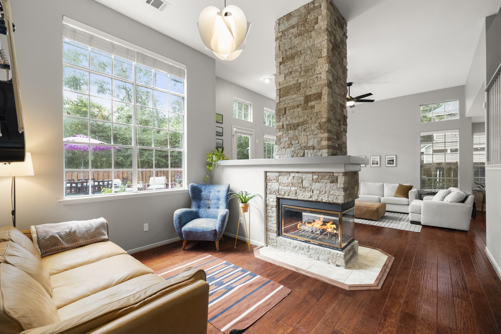 102 Treescape Circle Spring, TX 77381 - Photo 11 of 40 Enjoy a 2nd living space that shares the dual-sided stone fireplace, and is equally impressive with the wall of windows continued.