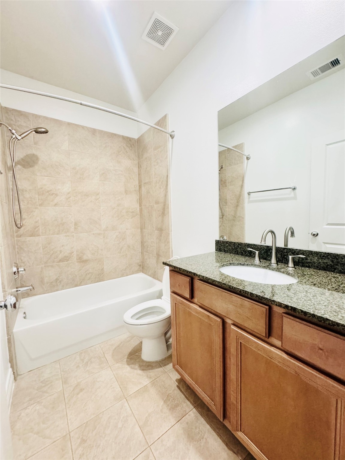 3846 Center Street Houston, TX 77007 - Photo 11 of 37 a bathroom with a granite countertop sink a toilet a mirror and shower