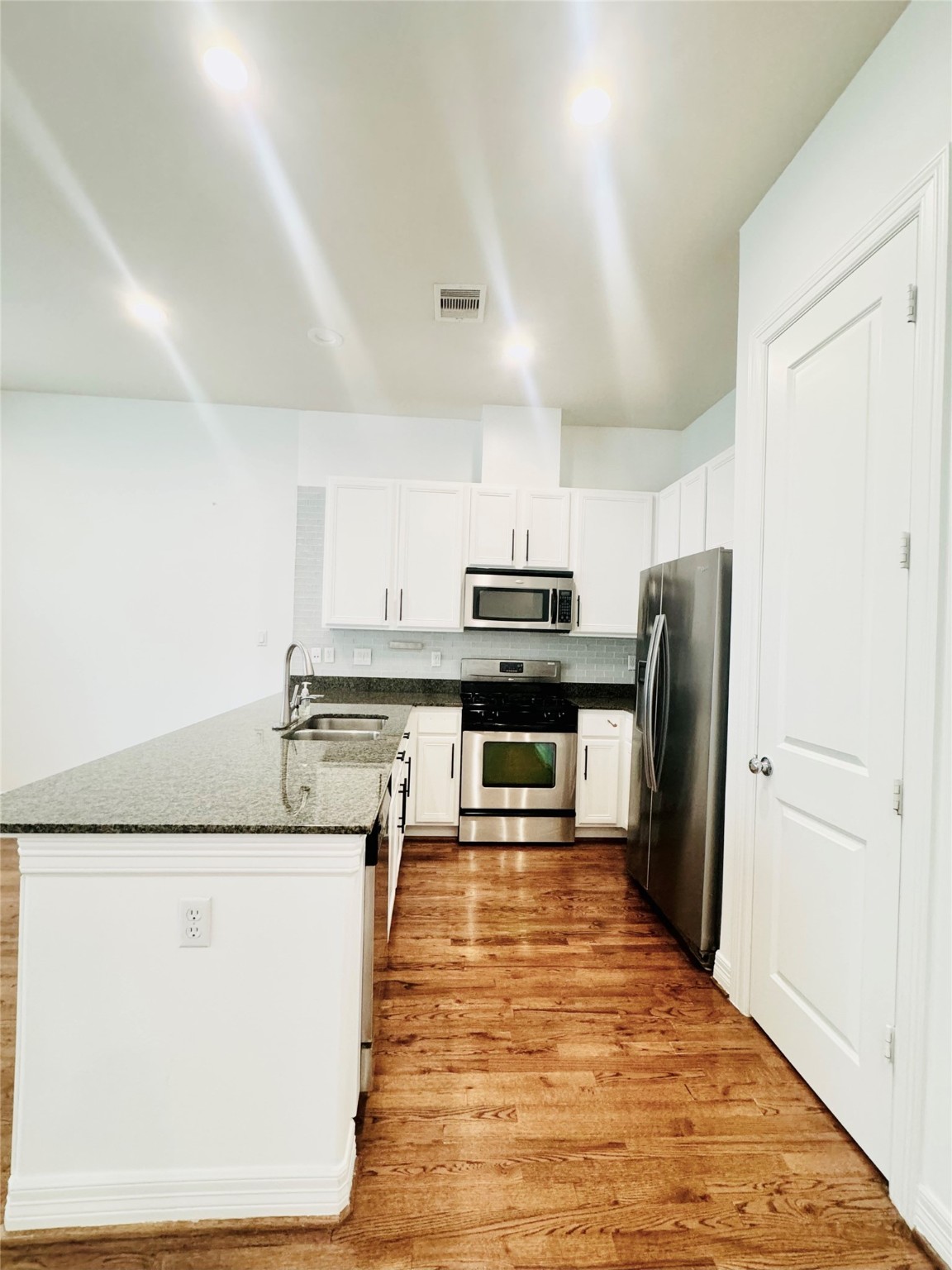 3846 Center Street Houston, TX 77007 - Photo 2 of 37 a large kitchen with stainless steel appliances kitchen island granite countertop a refrigerator a stove and a sink