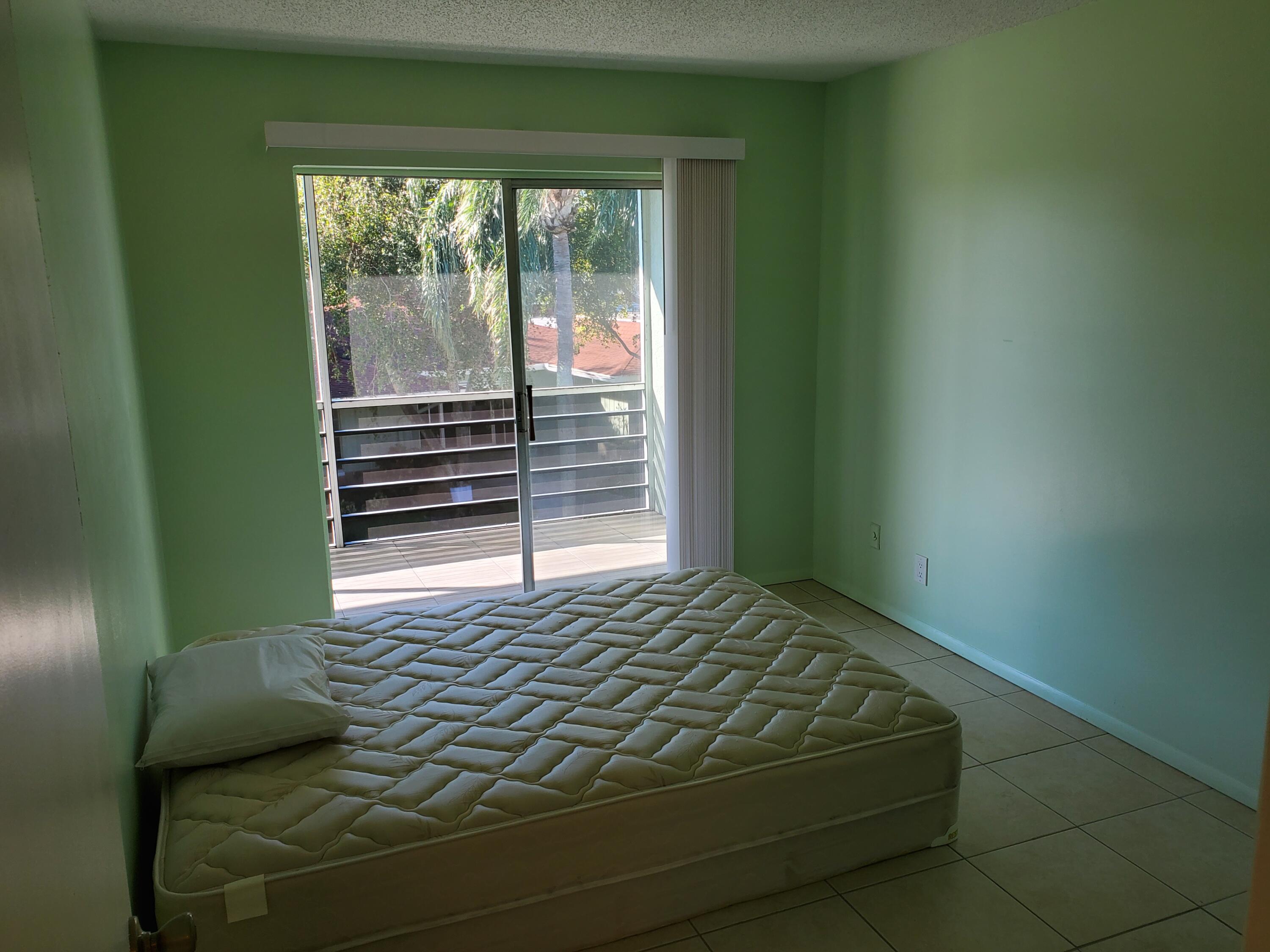 3300 Springdale Boulevard, Unit 318 Palm Springs, FL 33461 - Photo 18 of 34 a bedroom with a bed and a window