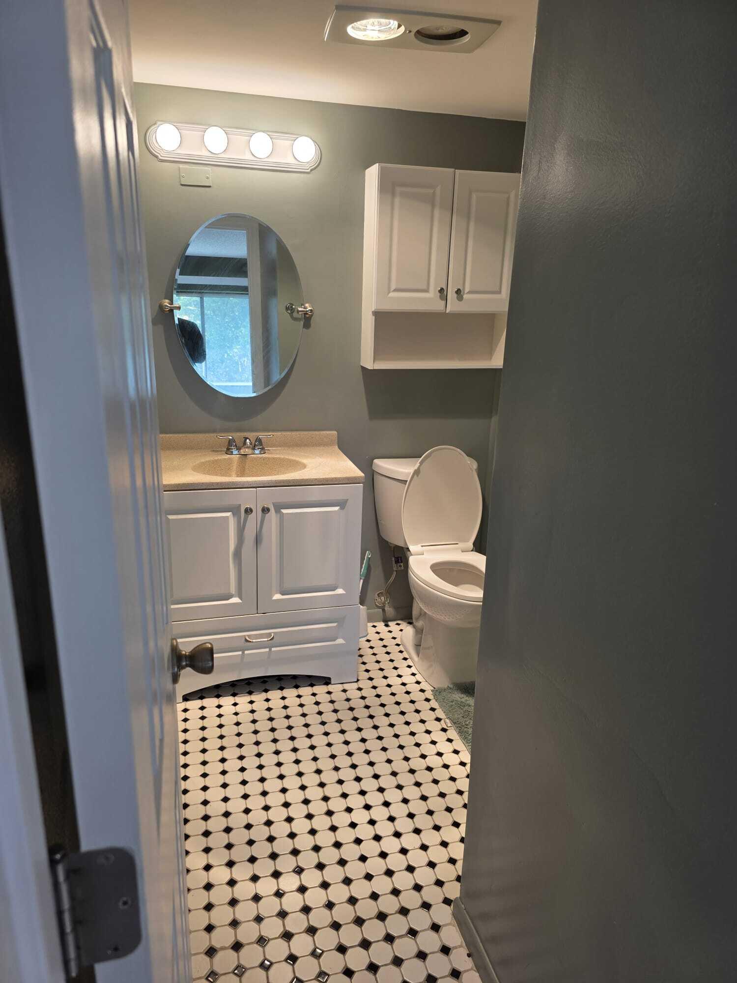 3300 Springdale Boulevard, Unit 318 Palm Springs, FL 33461 - Photo 28 of 34 a bathroom with a toilet a sink and mirror