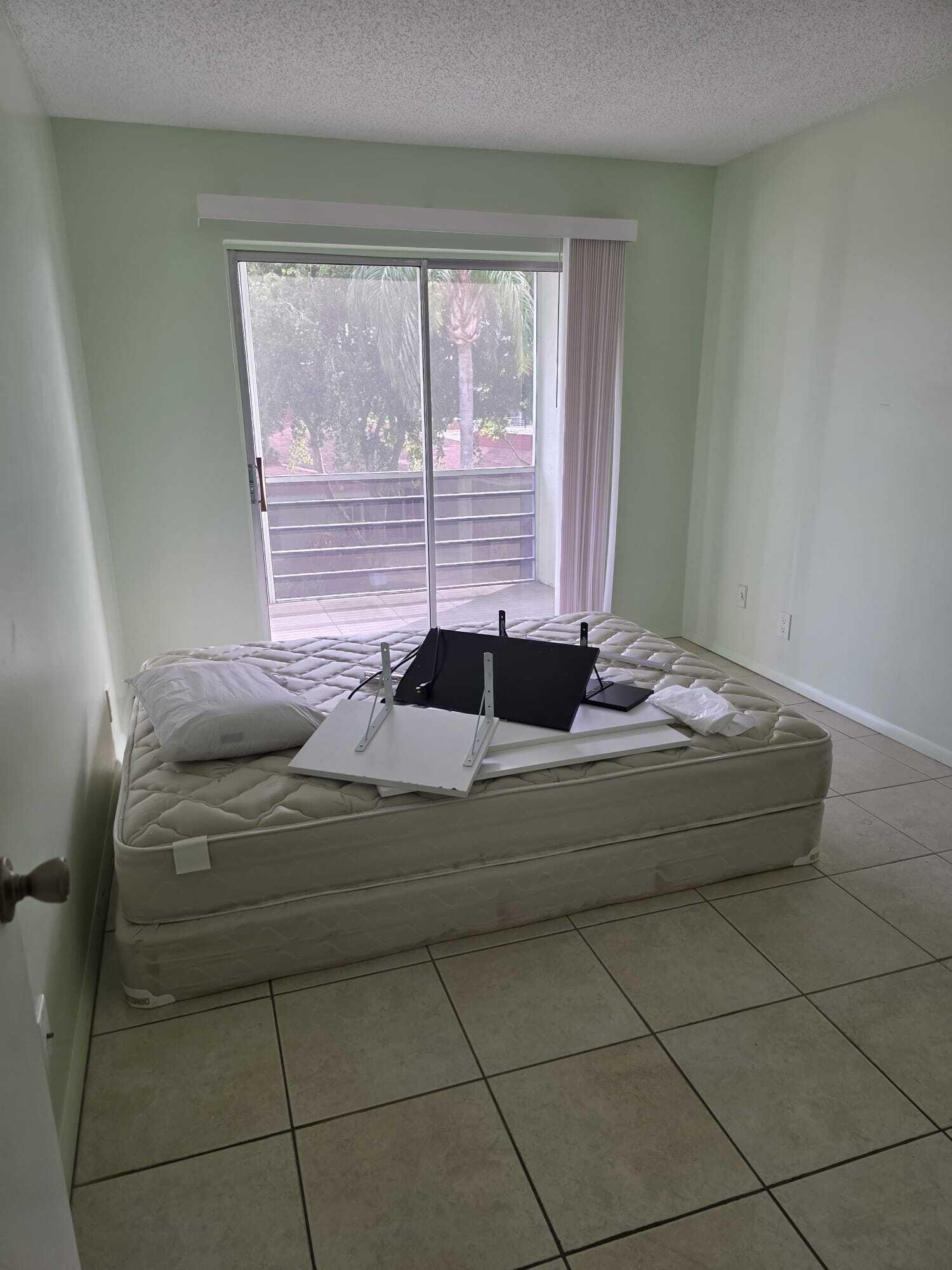 3300 Springdale Boulevard, Unit 318 Palm Springs, FL 33461 - Photo 32 of 34 a living room with a bed
