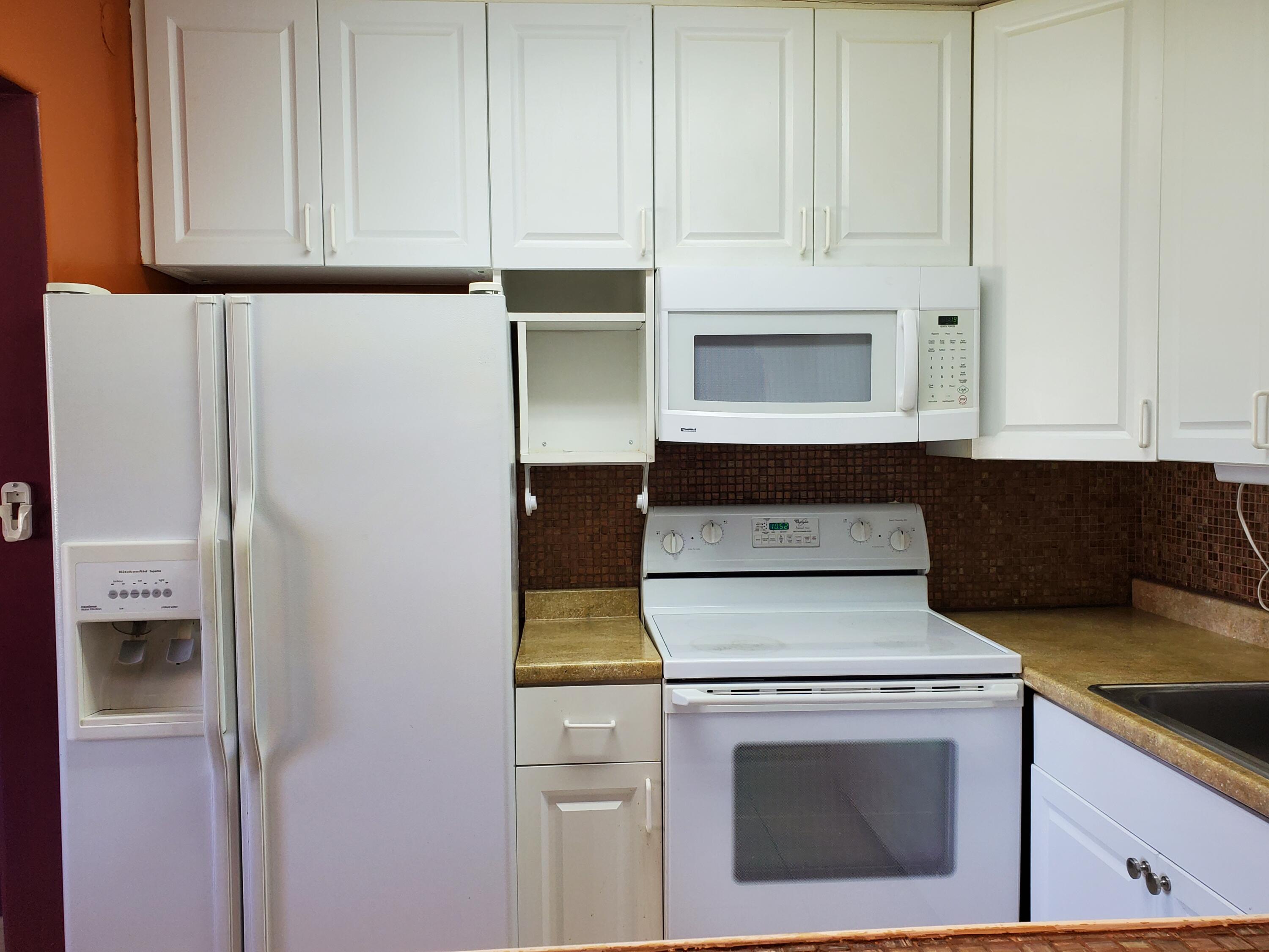 3300 Springdale Boulevard, Unit 318 Palm Springs, FL 33461 - Photo 9 of 34 a stove top oven sitting inside of a kitchen