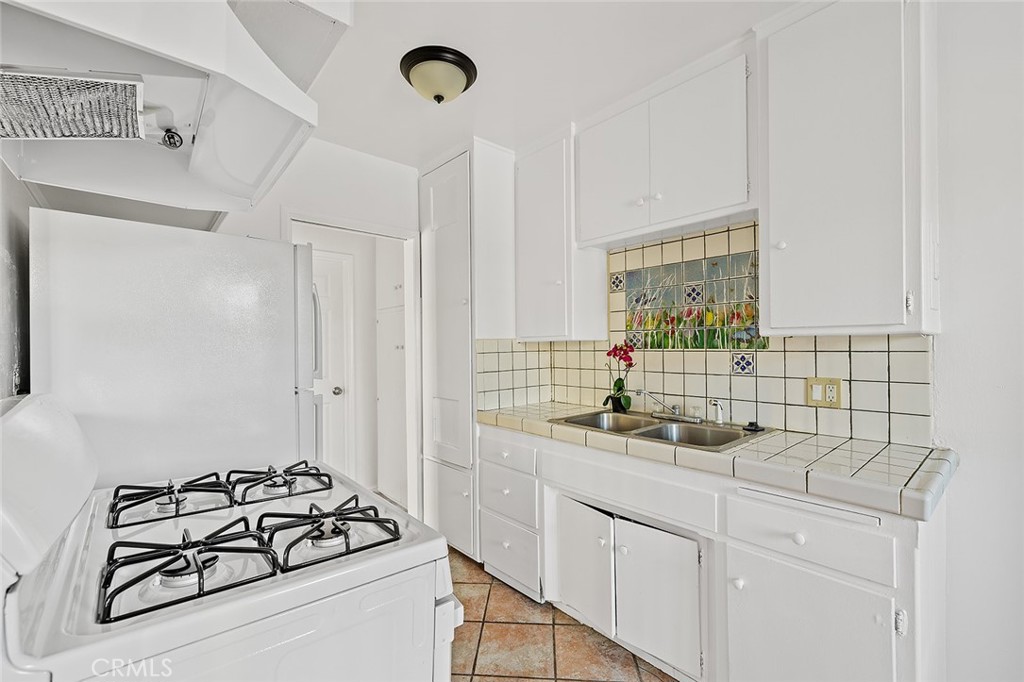 330 West Laurel Street, Unit C Compton, CA 90220 - Photo 11 of 16 a kitchen with sink a stove and white cabinets