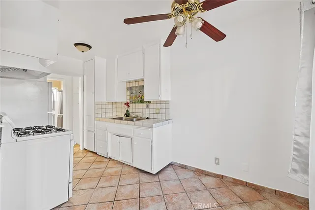 a kitchen with granite countertop white cabinets and white appliances
