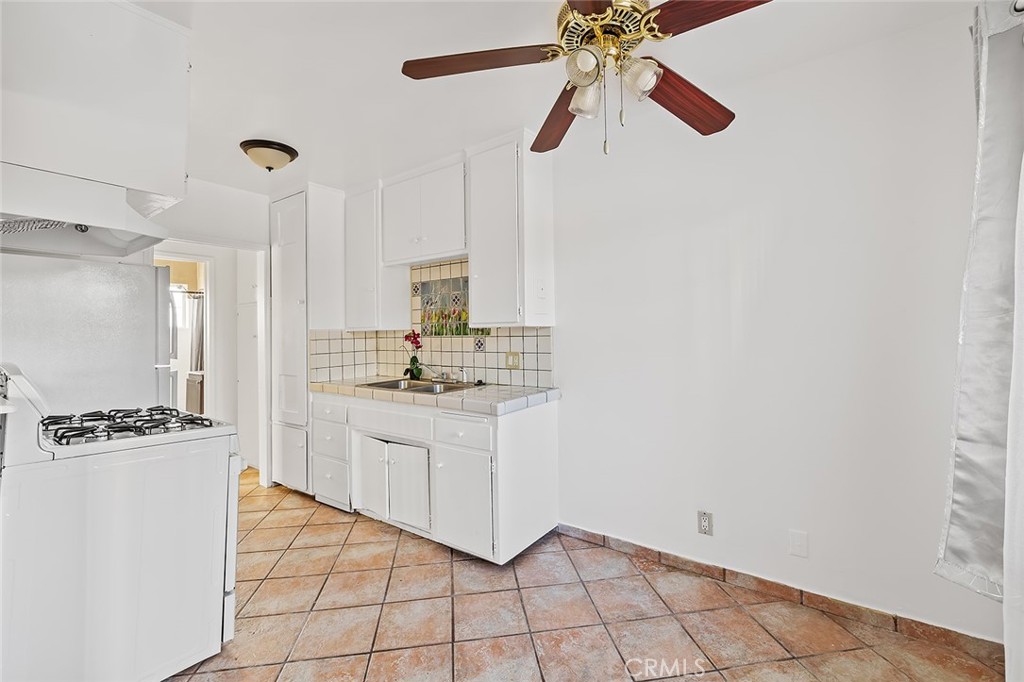 330 West Laurel Street, Unit C Compton, CA 90220 - Photo 9 of 16 a kitchen with granite countertop white cabinets and white appliances