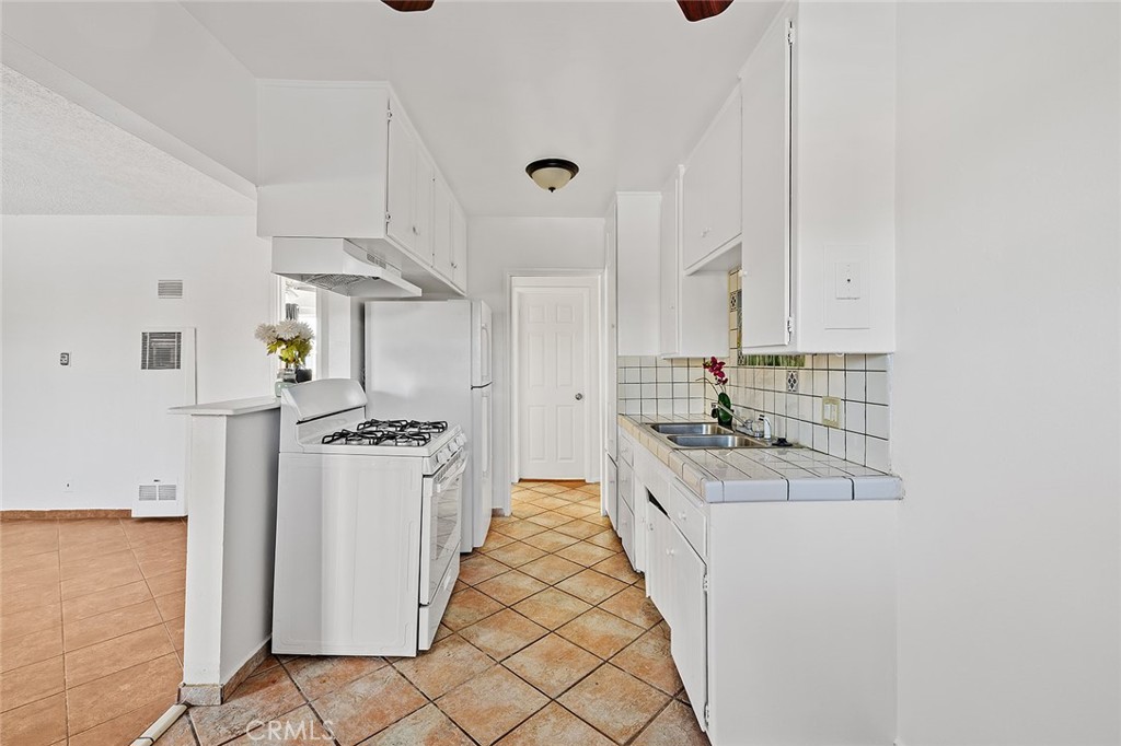 330 West Laurel Street, Unit C Compton, CA 90220 - Photo 10 of 16 a kitchen with stainless steel appliances granite countertop a stove and a refrigerator