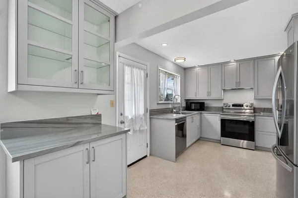a kitchen with stainless steel appliances granite countertop a refrigerator stove and sink