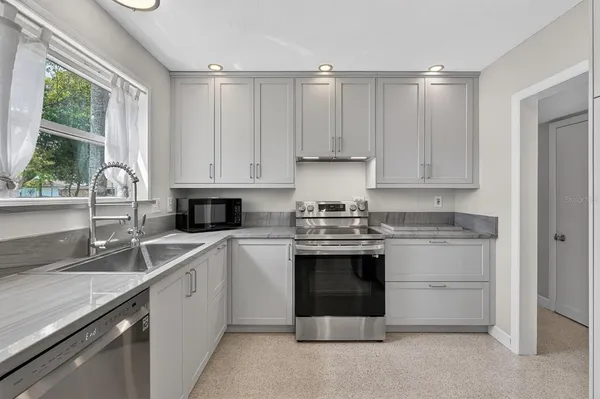 a kitchen with stainless steel appliances granite countertop a sink and a stove