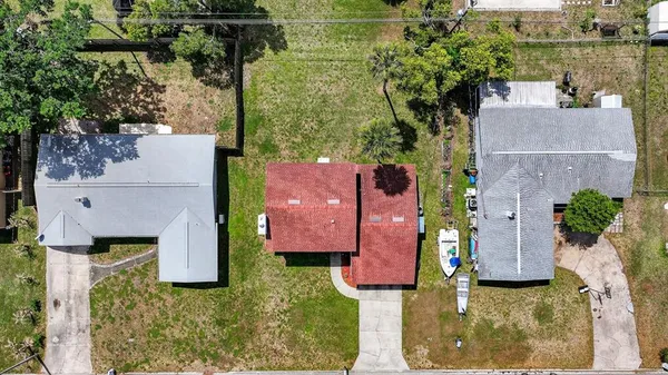 an aerial view of a house with a garden and lake view