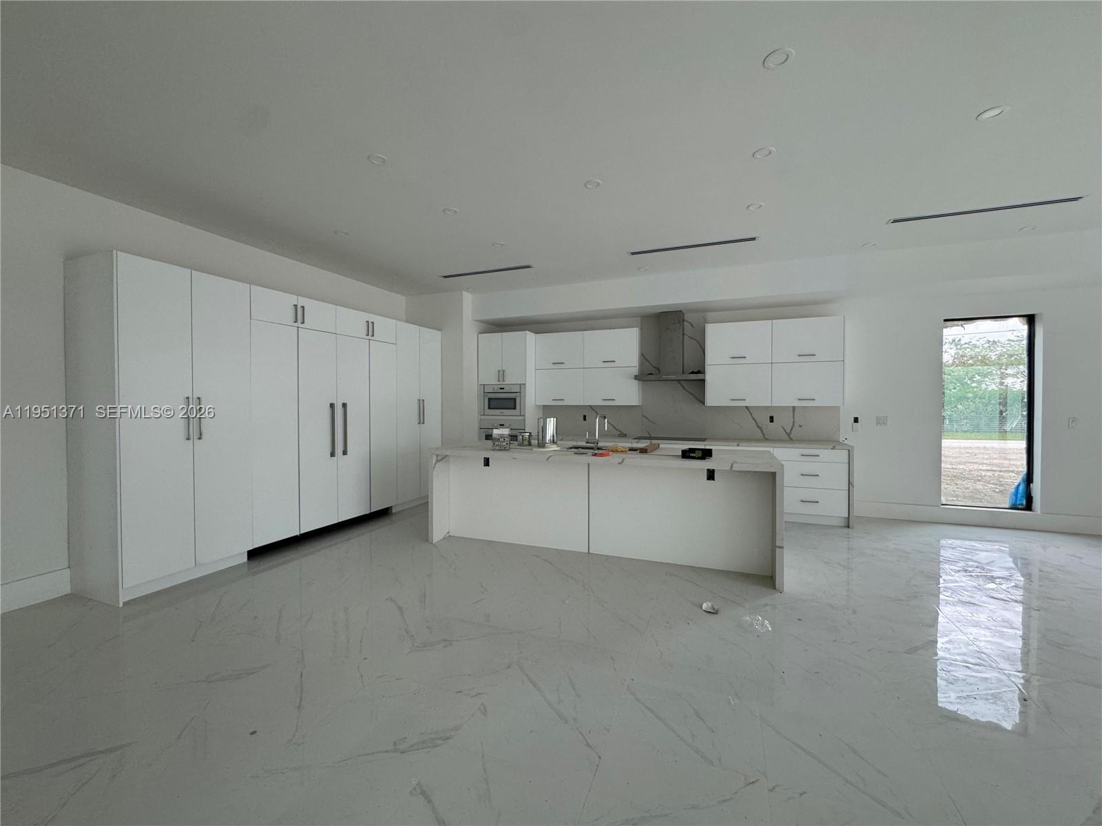 6190 Southwest 128th Street Pinecrest, FL 33156 - Photo 22 of 34 a large white kitchen with a white stove top oven and white cabinets