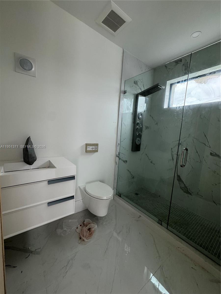 6190 Southwest 128th Street Pinecrest, FL 33156 - Photo 34 of 34 a bathroom with a toilet a sink and shower