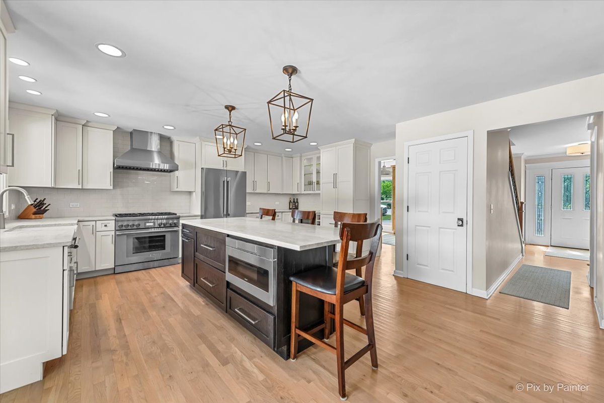 39W278 Baert Road St. Charles, IL 60175 - Photo 7 of 47 a large kitchen with stainless steel appliances a stove a sink dishwasher and a dining table with wooden floors