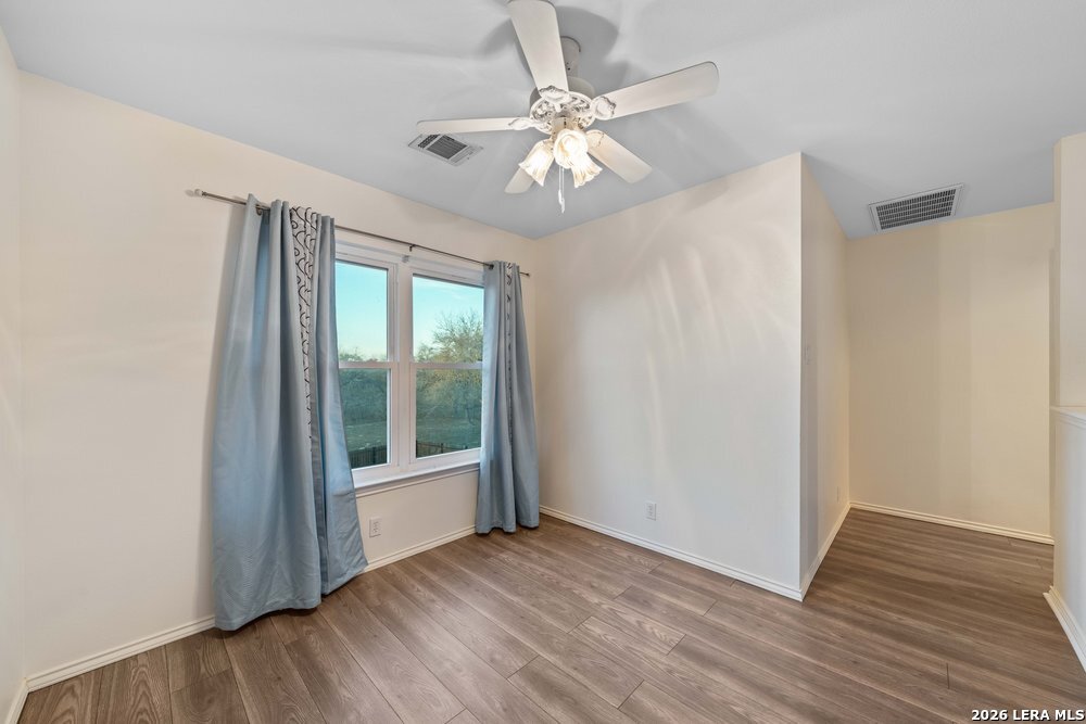 422 Arbor View Adkins, TX 78101 - Photo 17 of 29 a view of an empty room with wooden floor and a window