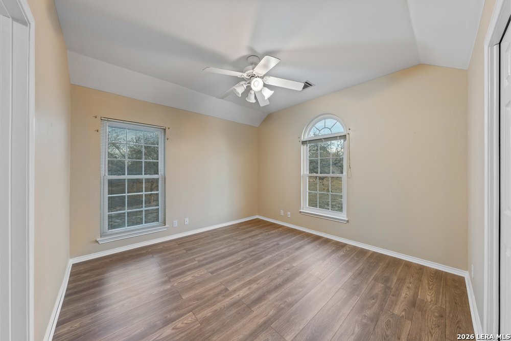 422 Arbor View Adkins, TX 78101 - Photo 18 of 29 an empty room with wooden floor chandelier fan and windows