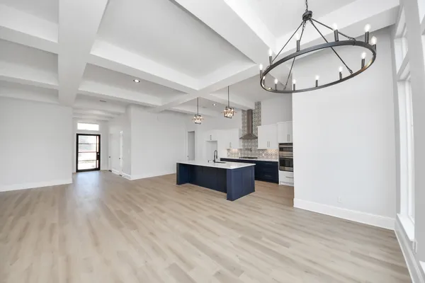 a view of kitchen with granite countertop cabinets and chandelier