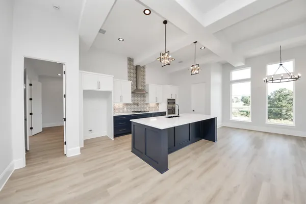 a kitchen with a stove a refrigerator a sink dishwasher with a dining table and chairs