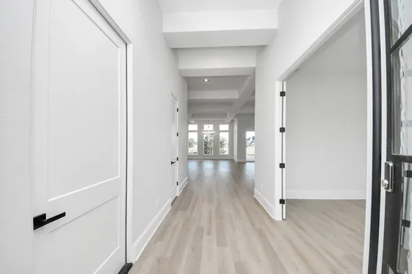 a view of a hallway with wooden floor