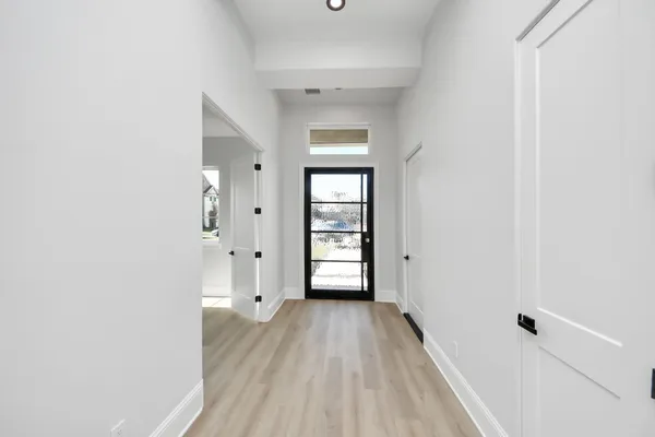 a view of a hallway with wooden floor and windows