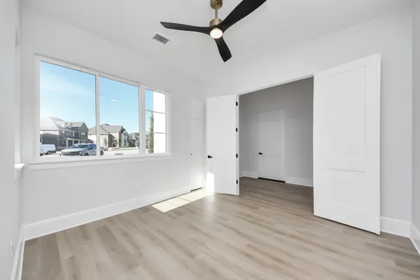 an empty room with wooden floor and windows