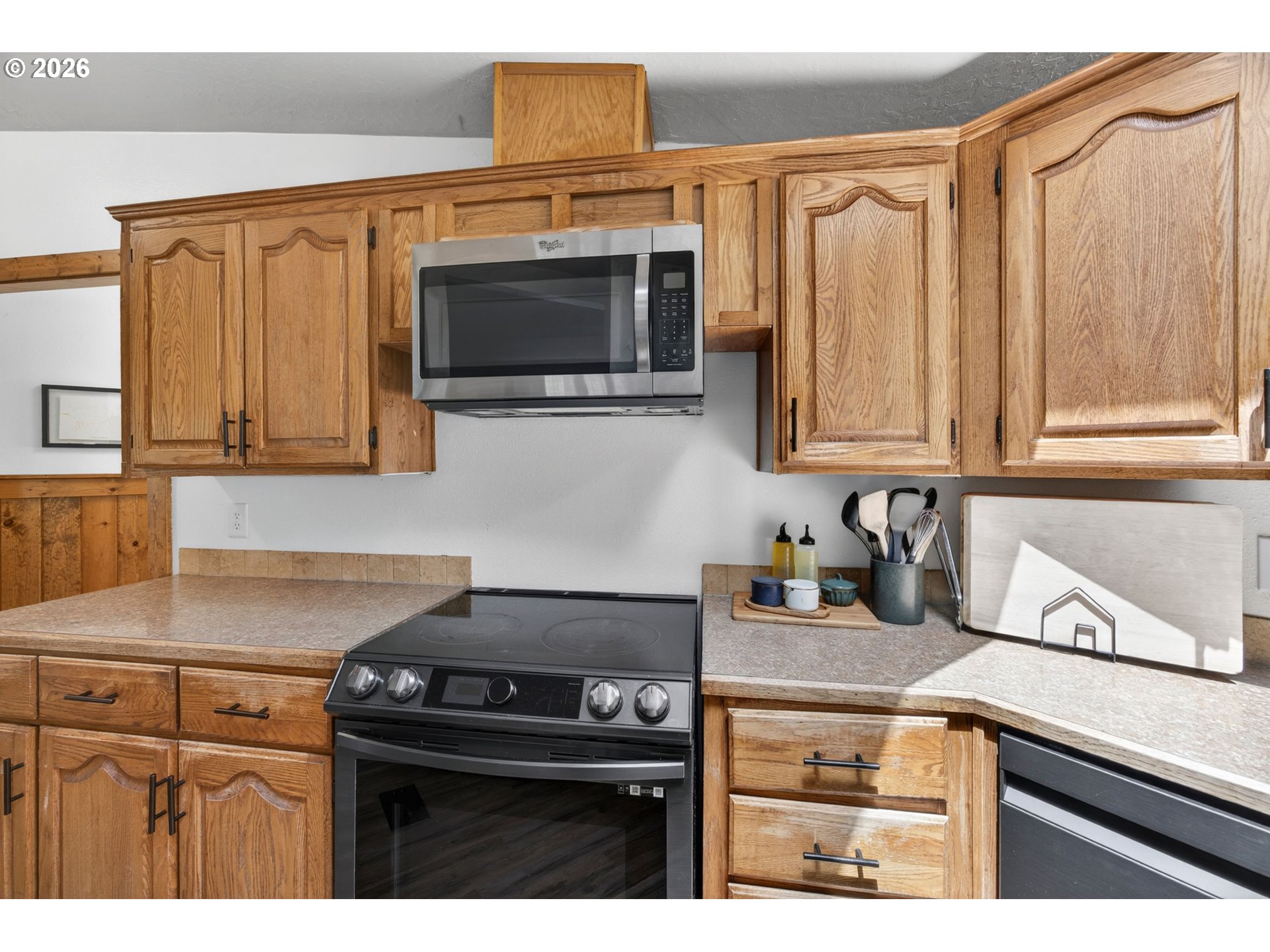 6895 Canary Road Westlake, OR 97493 - Photo 9 of 40 a kitchen with stainless steel appliances granite countertop a stove microwave and sink
