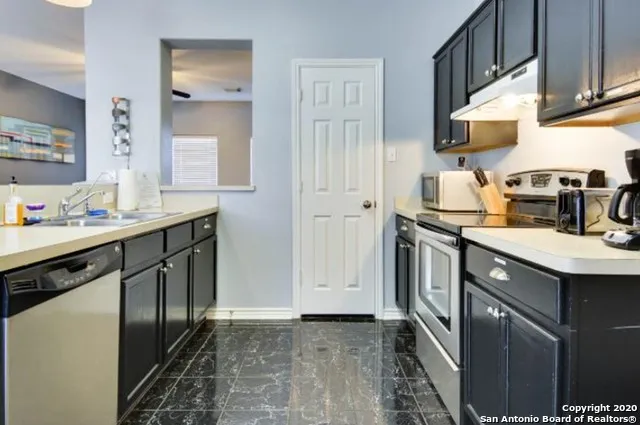 a kitchen with stainless steel appliances granite countertop a refrigerator and a sink