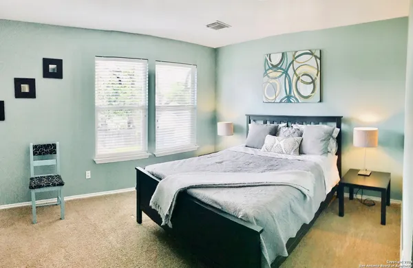 a bedroom with a bed and a painting on the wall