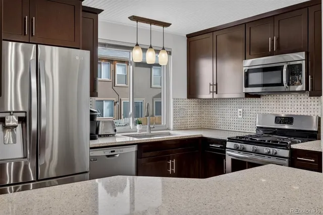 a kitchen with stainless steel appliances a refrigerator sink and microwave