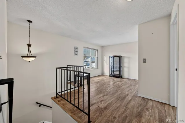 a view of a hallway with wooden floor and stairs