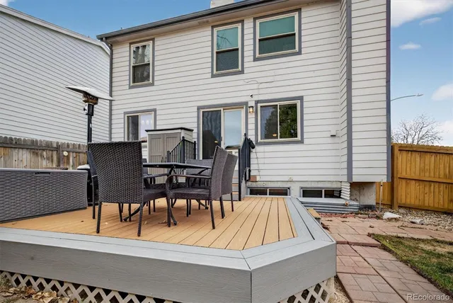 a view of a patio with table and chairs with wooden floor and fence