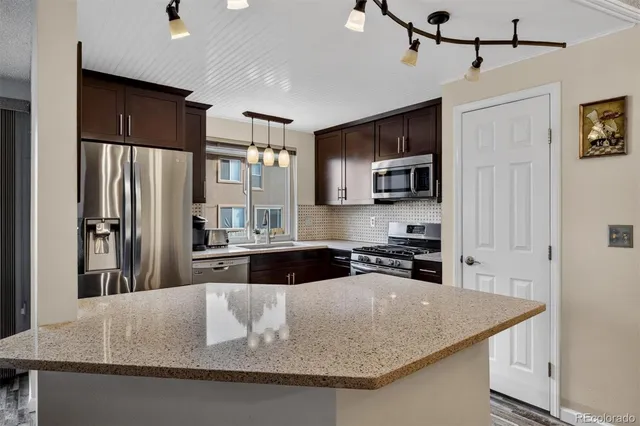 a kitchen with kitchen island a counter top space stainless steel appliances and cabinets