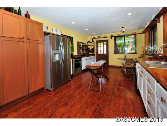 73 Magnolia Avenue St. Augustine, FL 32084 - Photo 8 of 22 a open kitchen with stainless steel appliances granite countertop a refrigerator a stove a sink dishwasher with a dining table and chairs with wooden floor
