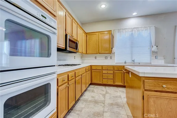 a large kitchen with stainless steel appliances granite countertop a sink and cabinets