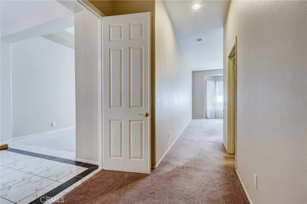 an empty room with a chandelier fan and windows