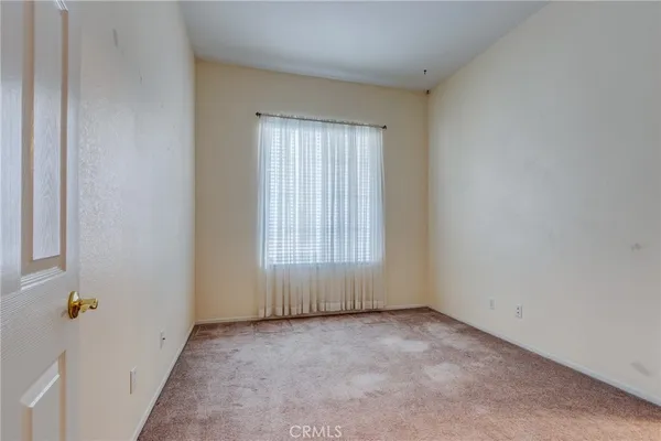 an empty room with a window and a ceiling fan