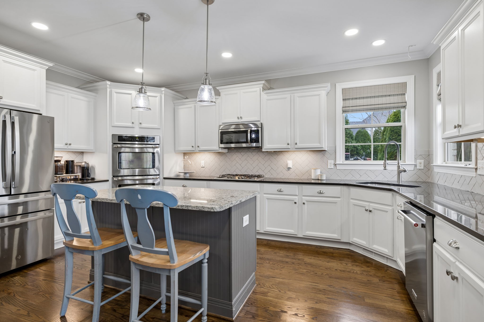 7005 Salmon Run Spring Hill, TN 37174 - Photo 31 of 85 a kitchen with stainless steel appliances granite countertop a stove a sink a microwave a refrigerator and white cabinets with wooden floor