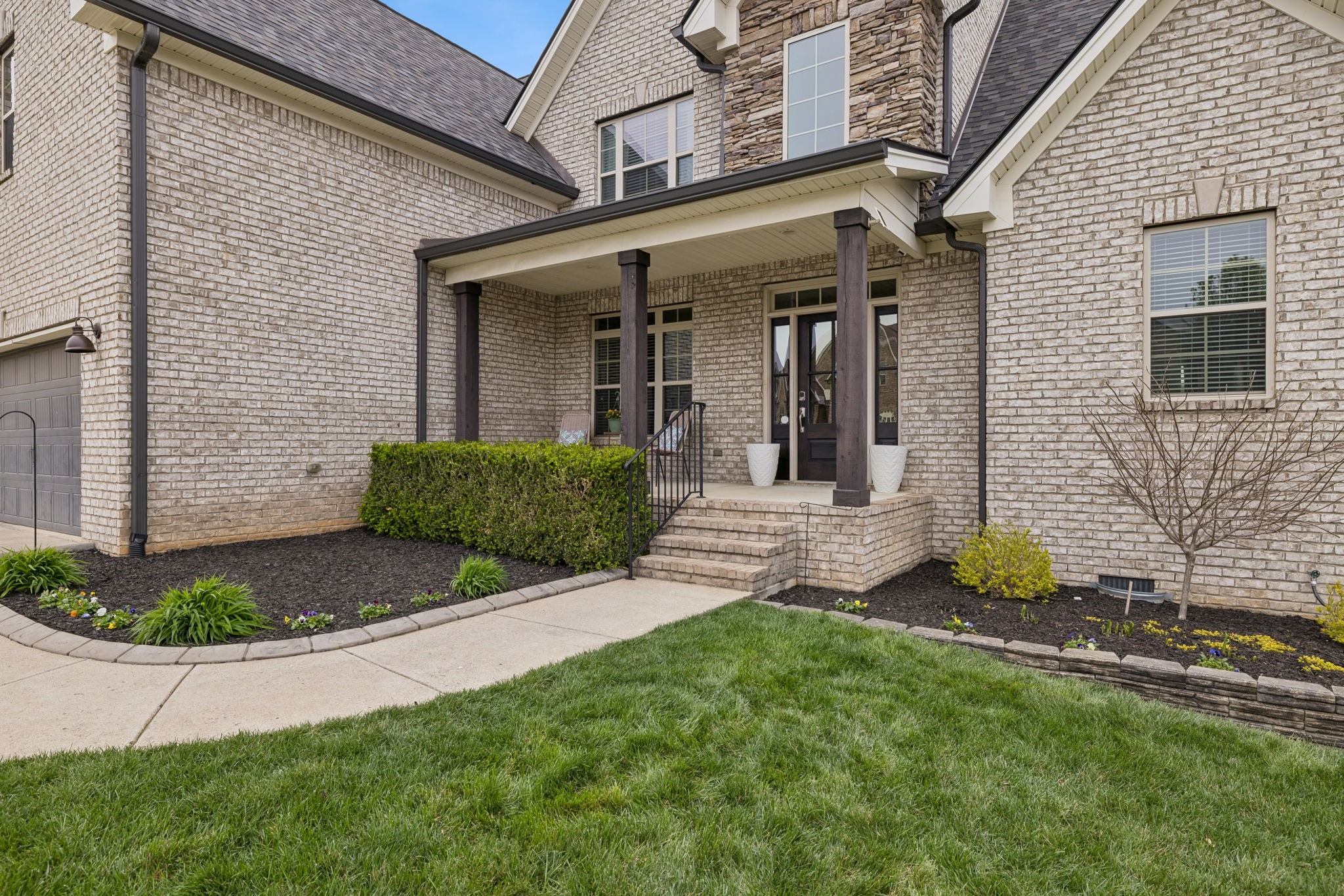 7005 Salmon Run Spring Hill, TN 37174 - Photo 5 of 85 a view of a brick house with many windows and plants