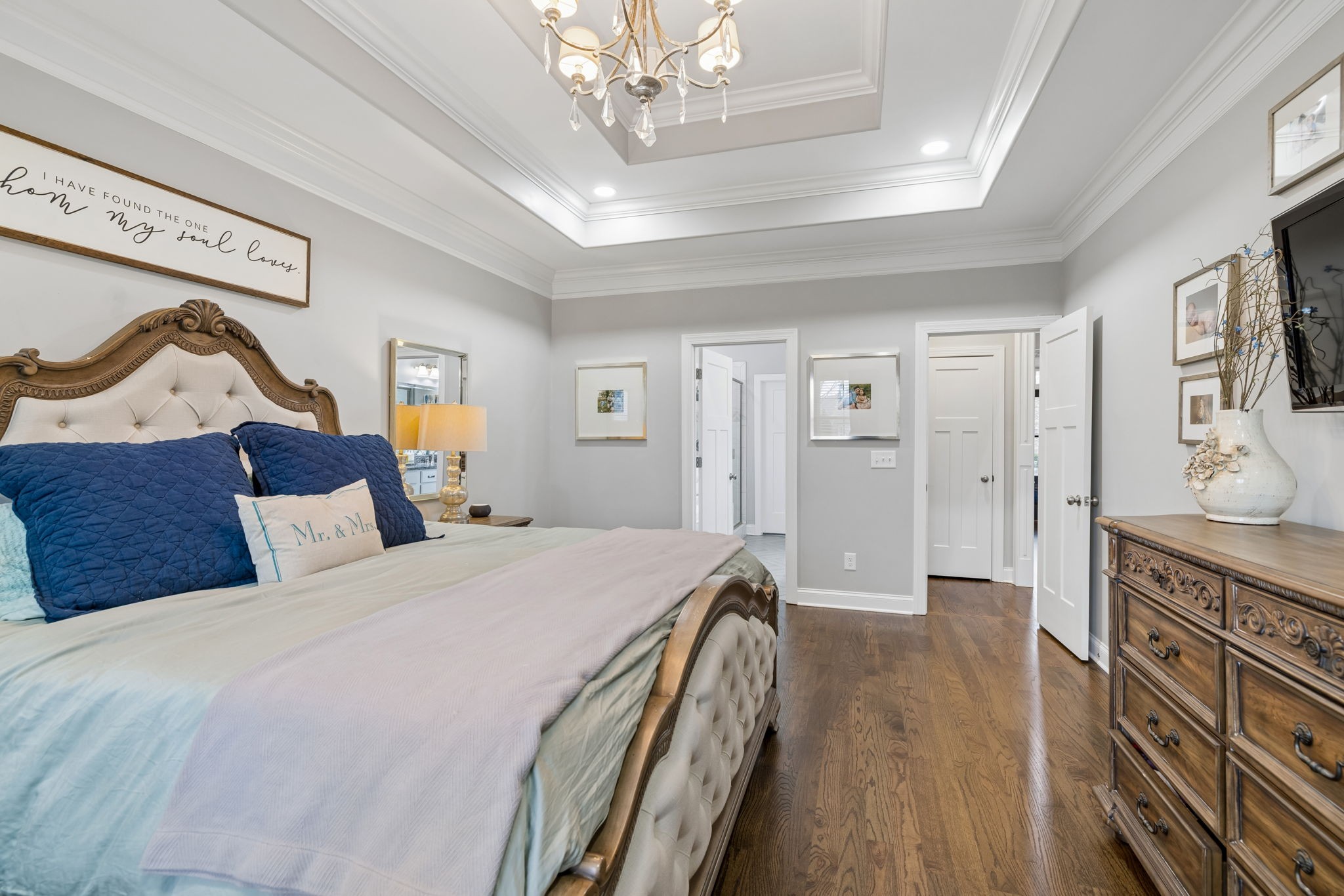 7005 Salmon Run Spring Hill, TN 37174 - Photo 51 of 85 a spacious bedroom with a bed a chandelier and a dresser