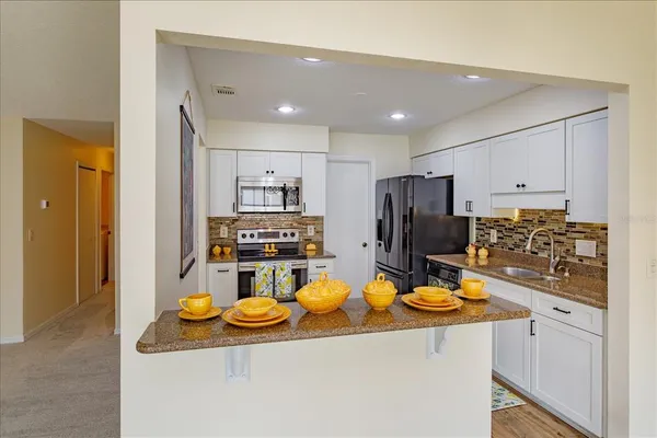 a kitchen with sink refrigerator and microwave
