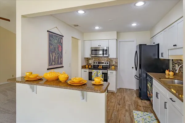 a kitchen with stainless steel appliances granite countertop a sink stove and refrigerator