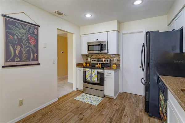a kitchen with stainless steel appliances a refrigerator and a stove top oven