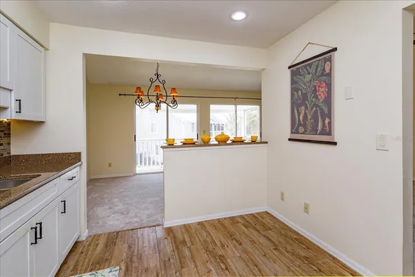 a view of a hallway with wooden floor and a refrigerator