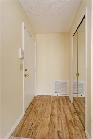 a view of a room with wooden floor and a bathroom