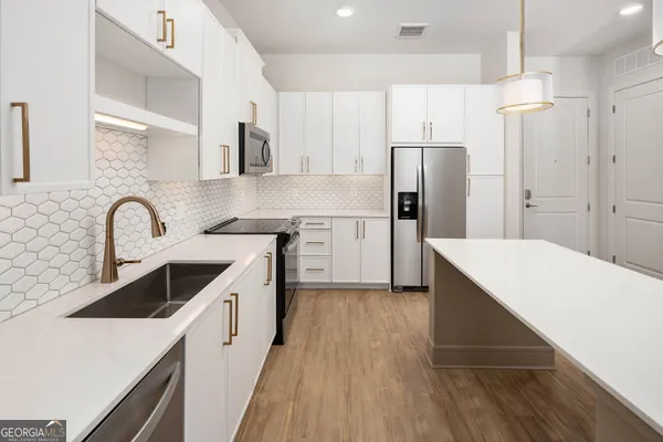 a kitchen with a sink a refrigerator and cabinets