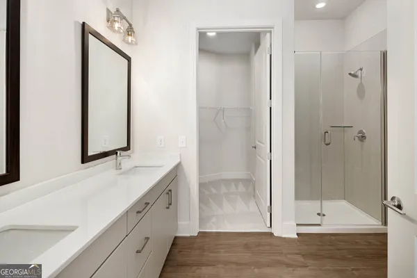 a bathroom with a double vanity sink mirror and shower